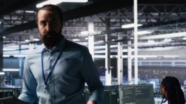 Sunucu odası makinesinin donanım öğrenmesi hakkında yatırımcılara brifing veren bir adam. Veri Merkezi Yöneticisi hissedarlara yapay zeka teknolojisi sunumunu kaydediyor, öngörücü bakım becerileri gösteriyor, kamera A