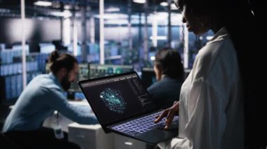 AI LLM görselleştirmesini izlemek için tablet kullanan veri merkezi teknisyenini kapatın. İşçi, sunucuların makine öğrenmesini denetlemek için aygıt üzerinde büyük dil modeli kullanır, kamera A