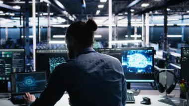 Sunucu odası yazılım geliştiricisi altyapı tanılarını gözden geçirmek için yapay zekayı kullanıyor. Veri merkezinde bilgisayar üzerinde yapay zeka teknolojisi kullanarak performans verilerini analiz eden bilişim çalışanı, kamera A