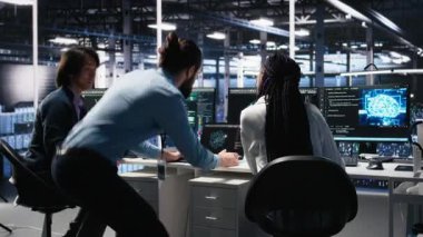 Ekip çalışması veri merkezi teknisyenleri büyük veri tabanlarını analiz etmek için makine öğrenme algoritmaları kullanıyorlar. Sunucu odası meslektaşları masasında bir araya gelerek, yapay zeka nöro ağları ve kamera A 'yı kullanarak işbirliği yaptılar.