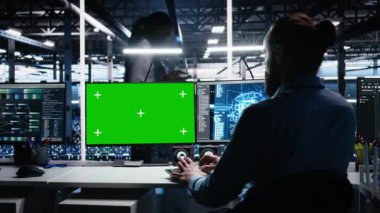 Yapay zeka sistemlerini kontrol eden veri merkezi mühendisi. Model PC kullanarak zaman ve verimlilik için. Sunucu merkezindeki izole ekran bilgisayarında yapay zeka kullanan bilişim uzmanı, kamera A