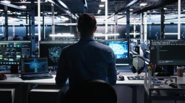 Veri merkezindeki cihazları kullanarak üretken yapay zeka yardımıyla kodlama yap. Bilgisayarda, laptopta ve tablette, kamera A 'da yapay zeka büyük dil modelleme teknolojisini denetleyen IT çalışanı.