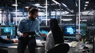 Veri Merkezi mühendislik ekibi üyeleri sinirsel ağ yazılım geliştirme konusunda işbirliği yapıyor. Sunucu merkezi iş yerinde makine öğrenme teknolojisi uygulayan iş arkadaşları, kamera A