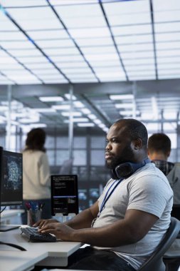 Farklı iş yükleri için bilgisayar kaynakları sağlayan yüksek teknolojili yapay zeka tesisinde çalışan bir mühendis. Veri merkezi süper bilgisayarlarını izlemekle görevli yapay zeka uzmanı