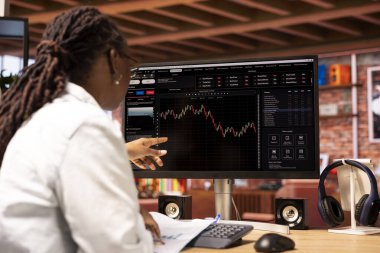 Borsacı hisse senedi alıp satmak için bilgisayar kullanıyor. Kârı maksimum seviyeye çıkarmak için dokümanların istatistiksel grafiklerine bakıyor. Bilgisayardaki borsa grafiklerine bakan yatırımcı