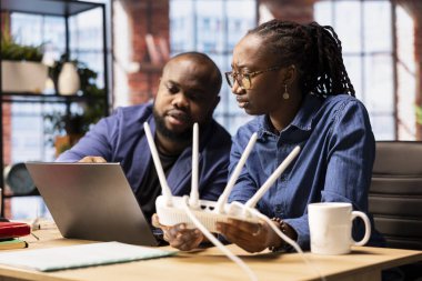 Genç adam ve kadın evdeki internet bağlantısıyla boğuşuyorlar, LAN kablosunu çıkarıyorlar ve sinyali geri getirmek için Wi-Fi ayarlarını ayarlıyorlar. Teknik sorunları olan serbest çalışan çift..