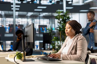 Ofis masasındaki kendine güvenen iş kadını rapor yazma ve cevap verme, idari işler yönetimi üzerinde çalışıyor. Siyahi kadın uzman başarıyı garanti altına almak için hedefleri gözden geçiriyor.