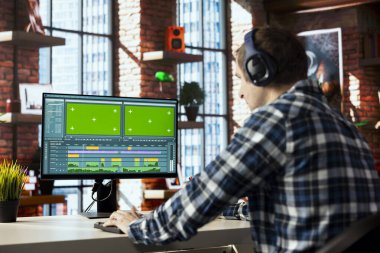 Model bilgisayardaki ham görüntüleri parlatmak ve ses kalitesini arttırmak için kulaklık kullanan bağımsız video editörü. Videograf, ses kulaklığı kullanarak yeşil ekran bilgisayar monitöründeki klipleri profesyonel olarak ayarlıyor