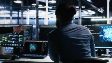 Veri merkezi sistem yöneticileri AI LLM kullanarak sinirsel ağı izlemek için PC kullanır. Asyalı adam ve iş arkadaşı sunucuların makine öğrenmesini denetlemek için yapay zeka kullanıyor. Kamera A