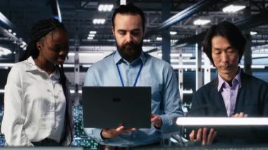 Üretken yapay zeka yardımıyla veri merkezi kodunda gülümseyen mühendislerin portresi. Mutlu bilişim uzmanları beyin fırtınası yapıyor, yapay zekaya baskı yapıyor görevleri çözmek için büyük dil modeli, kamera A