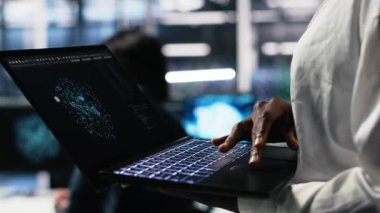 AI LLM görselleştirmesini izlemek için tablet kullanan veri merkezi teknisyenini kapatın. İşçi, sunucuların makine öğrenmesini denetlemek için aygıt üzerinde büyük dil modeli kullanır, kamera A