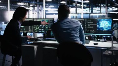 Veri merkezi sistem yöneticileri AI LLM kullanarak sinirsel ağı izlemek için PC kullanır. Asyalı adam ve iş arkadaşı sunucuların makine öğrenmesini denetlemek için yapay zeka kullanıyor. Kamera A