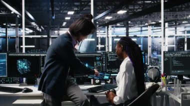 Veri merkezinde kıdemli mühendis ve stajyer sinirsel ağ yazılım geliştirme üzerinde çalışıyor. Sunucu odasında baş programcı ve stajyer PC, kamera A kullanarak makine öğrenme teknolojisi uyguluyorlar.