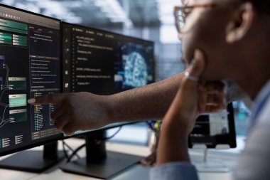 Teknisyen, iş arkadaşına yapay zeka ve makine öğrenme araçları kullanarak veri merkezi otomasyonu yapmayı öğretiyor. Sunucu merkezi operasyonlarında yapay zeka kullanan Afro-Amerikan çalışanlar