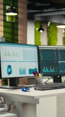 Dikey Video Boş şirket ofisi yüksek teknoloji ve çift monitörler, analitik araçlar iş stratejisi ve rapor yazma için hazır. Profesyonel büyüme ve örgütsel başarı.