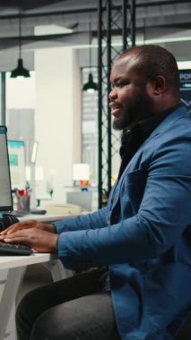 İşletme yönetimi için veri ve teknoloji kullanan Dikey Video Black çalışanı, raporlar oluşturmak ve verimliliği artırmak için monitördeki beyan grafiklerini gözden geçiriyor, hedeflere ulaşımı geliştiriyor. Vizyon. Kamera.