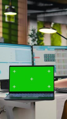 Dikey Video Şirketi personeli, dizüstü bilgisayardaki grafikleri analiz etmek, iş yönetimi verimliliğini artırmak ve büyüme hedeflerine ulaşmak için strateji raporları hazırlamak için ikili monitörler kullanır.