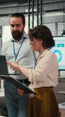 Vertical Video Diverse grup çalışanları performans ölçümlerini çalıştırmak için tablet üzerindeki grafiklerden elde edilen verileri kullanarak proje planlaması ve analizi üzerinde işbirliği yapmaktadır. Ekip çalışması ve iş birliği.