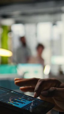 Erkeklerin tablet performans ölçüm ölçümlerini, iş stratejisini ve yenilikleri işyeri verimliliğini korurken izlediği dikey videoyu kapat. Hedeflere ve başarıya odaklanma