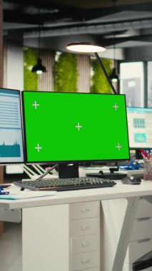 Çift monitörlerde yeşil ekranla donatılmış Dikey Video Çağdaş ofis alanı, profesyonel yönetim ve iş büyüme hedefleri için kullanılan boş çalışma istasyonu. Çokuluslu şirket görevleri.