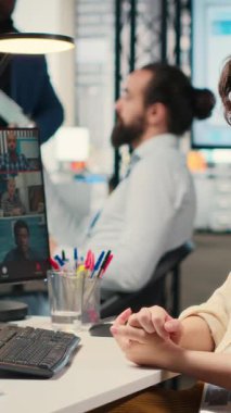 İş yerindeki bir web görüntülü konferans görüşmesi ile ilgili fikirleri paylaşan Dikey Video Çalışanları, proje brifingi hakkında çizelgeler ve raporlarla tartışıyorlar. Çevrimiçi toplantıya katılan iş ortakları