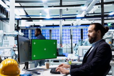 Erkek inşaat müteahhitleri üretim hattı için izole edilmiş ekranın yanındaki güneş paneli devrelerini test ederek, sanayi fabrikalarındaki sürdürülebilir çevre dostu enerji hedeflerini vurguluyor.