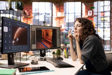 Kadın, fütüristik bir uzay gemisi istasyonu geliştirmek için yapay zeka uygulamasında çalışıyor. Sinirsel ağ destekli yazılım gerçekçi oyun ortamları oluşturmak için otomasyon ve makine öğrenme kullanır.