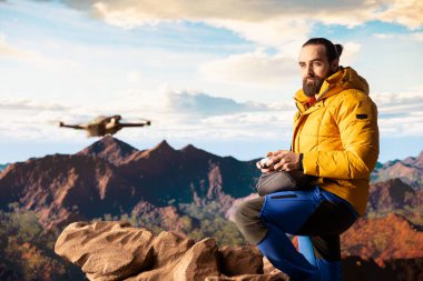 Seyahat meraklısı, insansız hava aracı görüntüleriyle onun faaliyetlerini yakalıyor. Manzaralı dağ aralığı vadisini belgeliyor. Uzaktan kumandalı güzel hava görüntüleme vlog 'u çekiliyor.