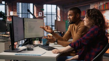 Başlangıç ofisindeki IT çalışanları bilgisayar masalarında çalışıyor, programları ve sistemleri test ediyor ve dağıtıyorlar. Masaüstü bilgisayarlarındaki kodları kontrol eden programcı ve geliştirici, çalışma alanındaki görevleri çözen, kamera A