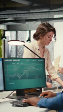 Dikey Görüntü İşyeri destek çalışanı dosya ve sözleşmelerle dolu bir teslimat arabasını hareket ettiriyor ve Afrikalı Amerikalı yöneticilere muhasebe işleri için arşivlenmiş belge yığınını getirmelerine yardım ediyor.