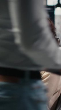 Dikey Video Genç iş kadını ofis görevlerini çözerken, içgörüleri veya KPI metriklerini bilgisayarda izlerken bir podcast 'e odaklandı. Dijital araçlarla genişleme planları için strateji raporları. Kamera B.