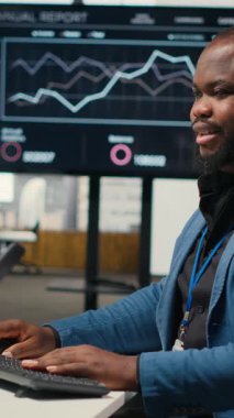 İşletme yönetimi için veri ve teknoloji kullanan Dikey Video Black çalışanı, raporlar oluşturmak ve verimliliği artırmak için monitördeki beyan grafiklerini gözden geçiriyor, hedeflere ulaşımı geliştiriyor. Vizyon. Kamera.