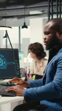 Dikey Video Afrikalı Amerikalı teknisyen yapay zeka finansal tahmin geliştirme üzerine çalışıyor. Sinir ağları ile birlikte bilgisayar üzerinde, derin öğrenme veri işleme. Karar vermek için uyarlanabilir algoritmalar. Kamera.