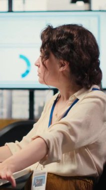 Dikey Video Ofisi yöneticisi AI analitik platformu ile aylık raporları kontrol ediyor, nöral ağ algoritmaları ve verimlilik için otomasyon kullanıyor. IT şirketi temsilcisi. Kamera B