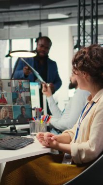 İş yerindeki bir web görüntülü konferans görüşmesi ile ilgili fikirleri paylaşan Dikey Video Çalışanları, proje brifingi hakkında çizelgeler ve raporlarla tartışıyorlar. Çevrimiçi toplantıya katılan iş ortakları