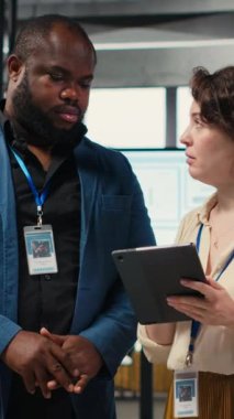 Dikey Video Çeşitli işçiler ekibi büyüme stratejisini geliştirmek için dijital araçlar ve analizler kullanır, modern bir ofiste yenilik ve kalkınmayı hızlandırmak için tablet üzerindeki finansal görüşleri gözden geçirir