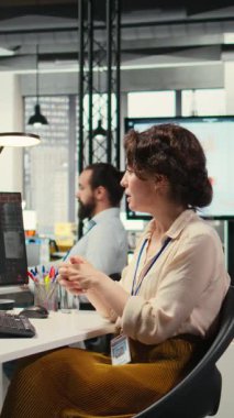 Dikey Video İş kadını, bir hissedarla İnternet sohbet etkinliğine katılarak, bir brifing için performans ölçümleri hakkında görüşlerini paylaşıyor. İş ortakları arasında ofiste video konferansı