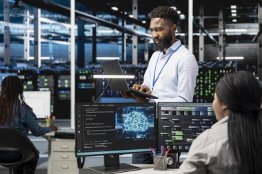 Veri merkezi programcısı yapay zeka sinirsel ağ teknolojisi kullanıyor. Bilgisayarda yapay zeka programlama dili kullanarak sunucu çiftliğinde çalışan Afrikalı Amerikalı bir adam, özel donanım yapılandırması