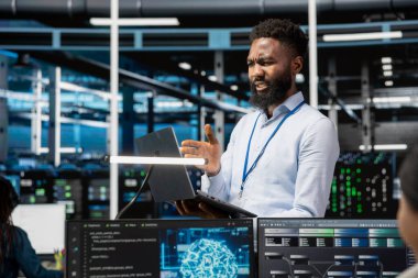 Veri merkezindeki yönetici yapay zeka kullanan bilgisayar modelini kullanıyor. Cihazları etkileyen aksaklıklar yüzünden kafası karışmış. Bozuk yapay zeka öğrenme algoritmalarından rahatsız olan somurtkan sunucu odası çalışanı