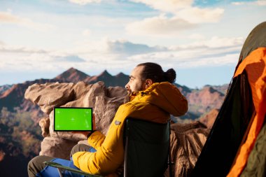 Kararlı dağcı, kişisel gelişimin yürüyüş yolculuğundan esinlenerek yeşil ekranın yanındaki dağ zirvelerinin keyfini çıkarıyor. Erkek yürüyüşçülerin macerası ve açık havanın güzelliği.