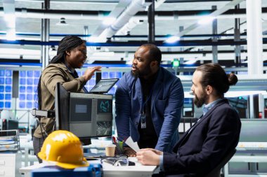 Fabrika mühendislerinden oluşan çok ırklı bir grup iş kıyafetleri kontrol ekipmanları ve üretim süreçleri, güneş paneli altyapısında profesyonel takım çalışması ve denetim gösterileri.