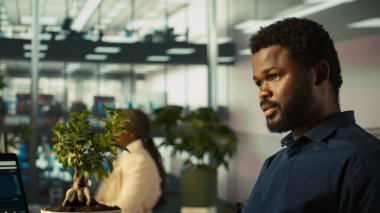 Görevli, ofisteki belgelerin gelir rakamlarını inceliyor. Ofisteki muhasebeci şirket istatistiksel numaralarını karşılaştırmaya, son teslim tarihinden önce işi bitirmek için sıkı çalışmaya odaklandı, kamera B