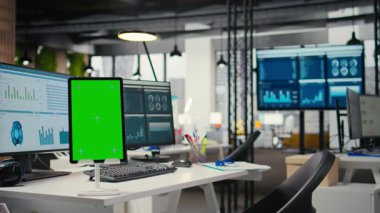 Modern boş ofis, iş yönetimi ve proje başarısını geliştirmek için profesyonel yönetim ve performans analizi için hazırlanan alan olan tablette yeşil ekranı gösteriyor.