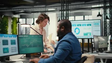 İşyeri destek çalışanı dosya ve sözleşmelerle dolu bir teslimat arabasını taşıyor ve Afrikalı Amerikalı yöneticilerin muhasebe işleri için arşivlenmiş belgeleri getirmesine yardım ediyor. Kamera B.