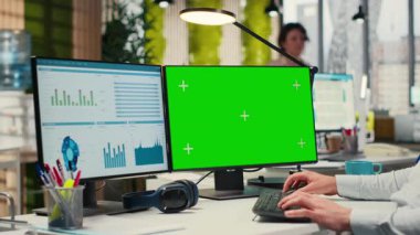 Ofiste yeşil ekran ile iş planlaması yapan çalışanlar, hedeflerle aynı hizayı sağlamak ve performans ölçümlerini optimize etmek için yazma raporları hazırlarlar. Şirket hava durumu. Kamera B.