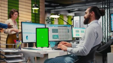 Erkek yönetici grafikler ve izole edilmiş maket ekran ile çalışarak uluslararası piyasada iş başarısı sağlıyor. Ofisteki küresel genişleme stratejisinin verileri gözden geçiriliyor. Kamera A.