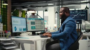 İş yönetimi için veri ve teknoloji kullanan siyah çalışanlar, raporlar oluşturmak ve verimliliği artırmak için monitördeki beyan grafiklerini gözden geçiriyorlar, hedeflere ulaşmak için. Vizyon. Kamera A.