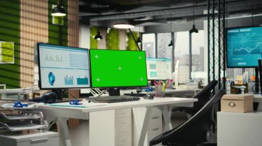 Çift monitörlerde yeşil ekranla donatılmış çağdaş ofis alanı, profesyonel yönetim ve iş büyüme hedefleri için kullanılan boş çalışma istasyonu. Çokuluslu şirket görevleri.