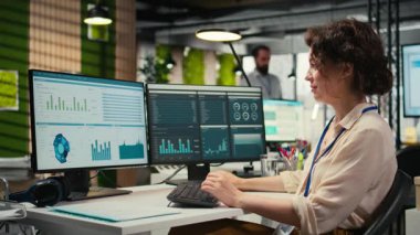 Yönetici bir bilgisayarda mali veri bilgileriyle ilgileniyor, yenilikçi iş çözümleri geliştiriyor ve proje hedeflerini şirket hedeflerine göre hizalıyor. Şirket ortamı. Kamera A.