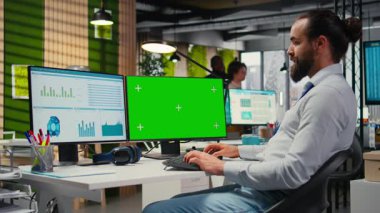 İşletme yöneticisi krom anahtar ekranın yanına yazı yazma üzerinde çalışıyor, ofisteki veri analizlerini inceliyor. Uzman vizyonlu bir iş stratejisi geliştirmek, ilerleme planlamak. Kamera A.